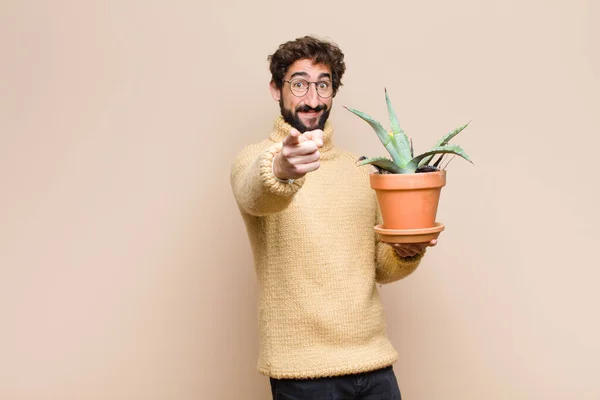 Jonge Koele Man Houdt Een Cactus Plant Tegen Platte Muur — Stockfoto