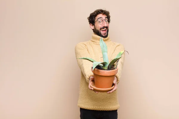Jonge Koele Man Houdt Een Cactus Plant Tegen Platte Muur — Stockfoto