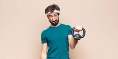 Spor salonunda sakallı, halterli genç bir adam. spor konsepti