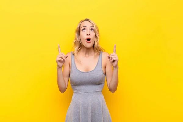 Young Blonde Woman Feeling Awed Open Mouthed Pointing Upwards Shocked — Stock Photo, Image