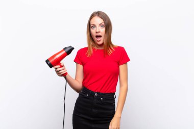 Kızıl saçlı güzel bir kadın şok olmuş ya da şaşırmış görünüyor, ağzı açık bakıyor ve kuaförü tuttuğunu söylüyor.