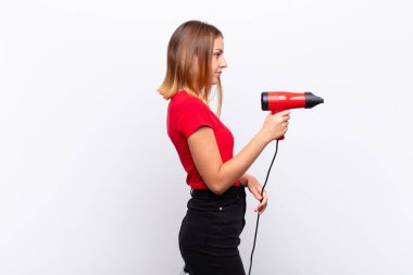 Profil görünümlü kızıl saçlı güzel bir kadın. Önündeki boşluğu kopyalamak istiyor. Düşünüyor, hayal ediyor ya da bir kuaförü kucağında tutuyor.