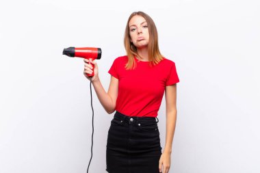 Kızıl saçlı, güzel bir kadın üzgün ve mızmız, mutsuz bir bakışla ağlıyor, negatif ve hayal kırıklığına uğramış bir şekilde bir kuaförü tutuyor.