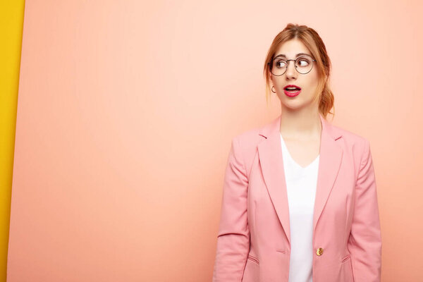 молодая симпатичная блондинка в шоке, счастлива, удивлена и удивлена, глядя в сторону с открытым ртом. бизнес концепция