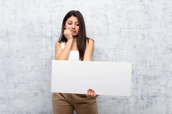 Junge Hübsche Frau Hält Ein Banner Gegen Grunge Wand — Stockfoto