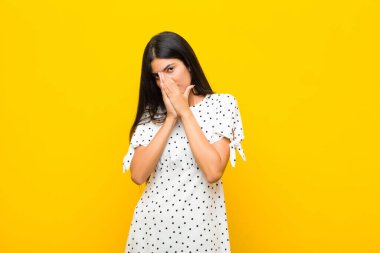 Genç, güzel, Latin bir kadın endişeli, umutlu ve dindar hissediyor, avuçlarına bastırılmış, düz duvara karşı af diliyor.