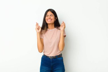 Genç ve güzel Latin bir kadın gergin ve umutlu. Dua ediyor ve düz duvara karşı iyi şanslar diliyor.