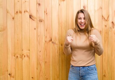 Genç sarışın kadın şok olmuş, heyecanlı ve mutlu, gülüyor ve başarıyı kutluyor,!