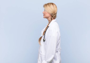 Profil görünümlü genç, güzel Latin kadın uzayı kopyalamaya çalışıyor. Düşünüyor, hayal ediyor ya da hayal kuruyor. doktor konsepti