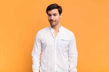 Şaşkın ve kafası karışmış genç bir adam gergin bir hareketle dudağını ısırıyor, sorunun cevabını bilmiyor.