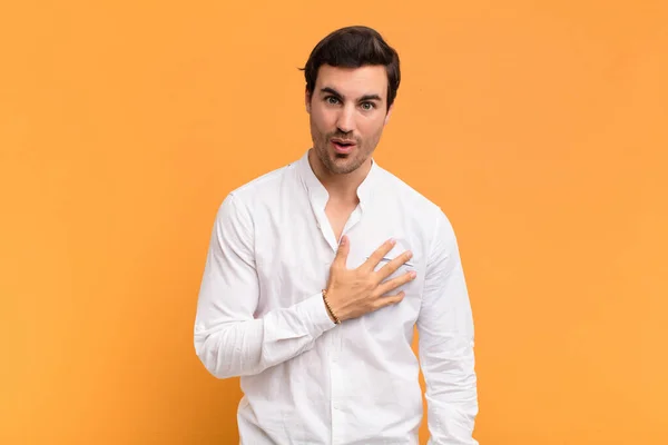 Junger Gutaussehender Mann Schockiert Und Überrascht Lächelnd Die Hand Herzen — Stockfoto