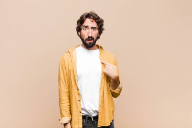 Kafası karışmış, kafası karışmış ve kendine güveni olmayan genç, çılgın bir adam kendini gösterip kim olduğumu soruyor, ben mi? yassı duvara karşı