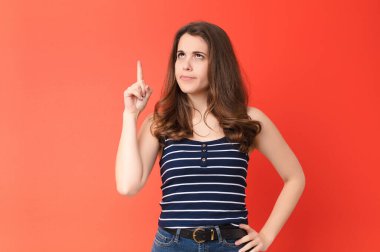 Genç ve güzel bir kadın, kırmızı duvara karşı 