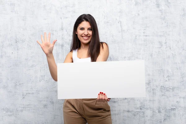 Junge Hübsche Frau Hält Ein Banner Gegen Grunge Wand — Stockfoto