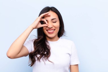 Duvara yaslanmış genç Latin güzel kadın.