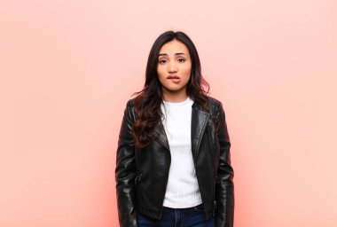 Genç, Latin, güzel bir kadın hangi seçeneği seçeceği konusunda kafası karışık ve kararsız hissediyor. Düz duvara karşı sorunu çözmeye çalışıyor.