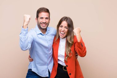 Genç ve güzel bir çift bej düz duvara karşı