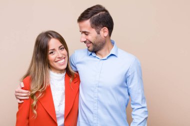 Genç ve güzel bir çift bej düz duvara karşı