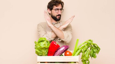 Yeşil manavın canı sıkkın görünüyor ve tavrından bıktı. Yeter artık! Eller önde çapraz, durmanı söylüyor.