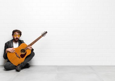 Genç müzisyen şok olmuş ya da şaşırmış görünüyor, ağzı açık gitar, rock 'n roll konseptiyle 