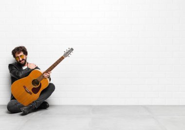 Genç müzisyen kendini endişeli, hasta, hasta ve mutsuz hissediyor. Ağrılı bir mide ağrısı ya da grip geçiriyor. Gitar, rock 'n roll konseptiyle.