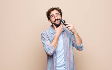 # Elektrikli tıraş makineli genç sakallı adam #