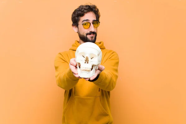 Ung Galen Cool Man Håller Mänsklig Dödskalle Modell Mot Orange — Stockfoto