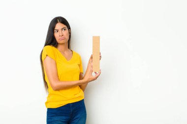 Genç Latin güzel kadın üzgün, depresif, mutsuz, bir kelime ya da cümle oluşturmak için alfabe I harfini tutuyor..
