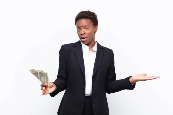 年轻漂亮的黑人女人张开嘴 惊讶于用美元钞票做的令人难以置信的惊喜 — 图库照片