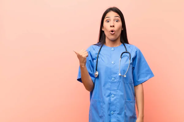 Young Latin Nurse Looking Astonished Disbelief Pointing Object Side Saying — Stock Photo, Image