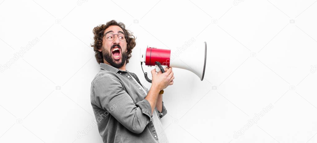 young crazy cool man with a megaphone against white wall