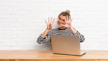  Gülümsüyor ve dost canlısı görünüyor, 9 ya da 9 numarayı gösteriyor, eli önde, geri sayıyor.