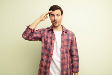 Genç yakışıklı adam mutlu, şaşkın ve şaşırmış görünüyor, gülümsüyor ve inanılmaz ve inanılmaz iyi haberleri fark ediyor.