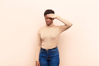 Genç ve güzel siyah kadın stresli, yorgun ve hayal kırıklığına uğramış, alnından ter damlayan, umutsuz ve bitkin hisseden.