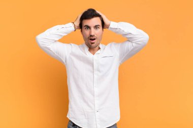 Adam heyecanlı ve şaşırmış görünüyor, ağzı açık, elleri başının üstünde, şanslı bir kazanan gibi hissediyor.