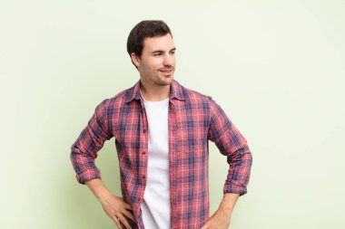 Mutlu, neşeli ve kendinden emin görünen, gururla gülümseyen ve iki elini de kalçasında görmek isteyen bir adam.