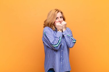 Orta yaşlı bir kadın endişeli, stresli ve korkmuş görünüyor, tırnaklarını yiyor ve yanal fotokopi için yer arıyor.