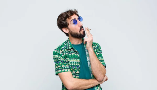 年轻的嬉皮士男子靠着白墙抽大麻 — 图库照片