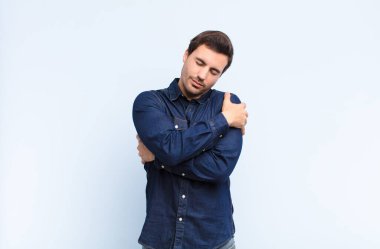 Genç yakışıklı adam aşık, gülümseyen, sarılan ve kendine sarılan, bekar kalan, bencil ve benmerkezci biri.