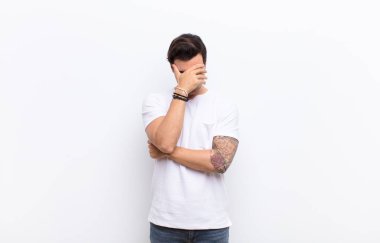 Stresli, utanmış ya da üzgün görünen bir adam. Başı ağrıyordu. Yüzü elle kaplıydı.