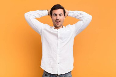 Genç yakışıklı adam mutlu, kaygısız, arkadaş canlısı ve rahat görünüyor. Hayattan ve başarıdan keyif alıyor, olumlu bir tavırla.