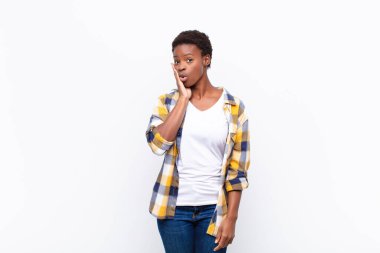 Genç ve güzel siyah kadın şoke olmuş ve ağzı açık bir şekilde yüz yüze inanmamakta zorlanıyor.