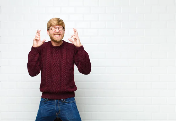 Jonge Blonde Man Voelt Zich Nerveus Hoopvol Kruisen Vingers Bidden — Stockfoto