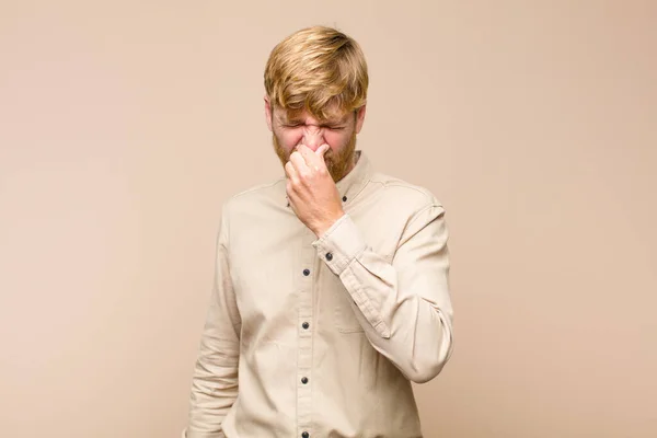 Young Blonde Man Feeling Disgusted Holding Nose Avoid Smelling Foul — Stock Photo, Image