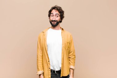 Genç çılgın adam merak ediyor, mutlu düşünceler ve fikirler düşünüyor, hayal kuruyor, düz duvara karşı uzayı kopyalamaya çalışıyor.