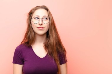 Genç sarışın kadın merak ediyor, mutlu düşünceler ve fikirler düşünüyor, hayal kuruyor, kenarda yer arıyor.