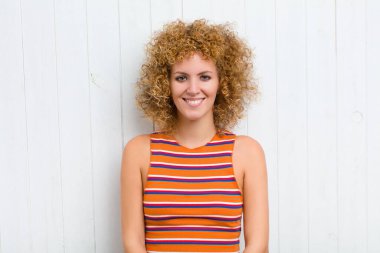 Genç, güzel bir kadın kameraya gülümsüyor ve mutlu, kendinden emin, tatmin olmuş bir ifade..