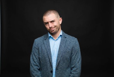 Genç işadamı kafası karışık ve kuşkulu hissediyor, merak ediyor ya da düz duvara karşı karar vermeye çalışıyor.