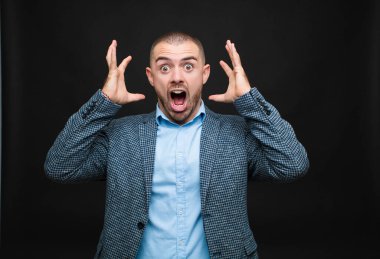 Genç işadamı elleri havada bağırıyor, öfkeli, sinirli, stresli ve üzgün hissediyor.
