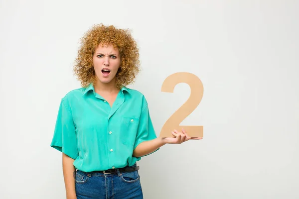 Young Pretty Afro Woman Confused Doubtful Thinking Holding Number — Stock Photo, Image